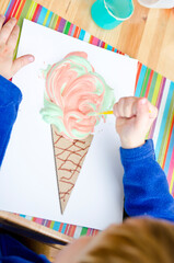 Drawing for children, little artists. Finger paints, free time for toddler. Ice cream cone made of recycled cardboard.