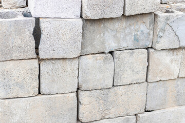 Close-up of used and damaged grey cinder blocks put in a row. Construction idea concept
