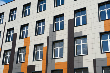 facade of a modern building on a bright Sunny day, siding and Windows, beautiful exterior of the new building