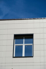 facade of a modern building on a bright Sunny day, siding and Windows, beautiful exterior of the new building