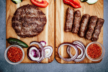Kitchen board with vegetables and Turkish cevap and burger