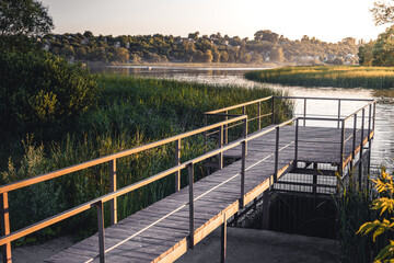 sun illuminates a small pier by the river. The concept of outdoor recreation and calm life. relaxation