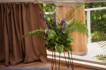 Fototapeta premium a bouquet of fern and lpin stands in a vase