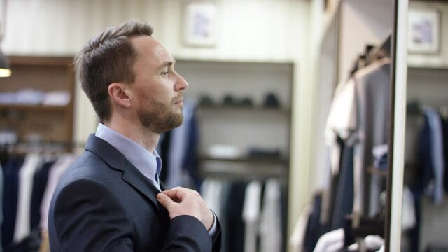 A side view slow motion close up of a business man in a suit looking closely at himself in the mirror evaluating his appearence