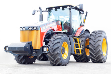 Obraz premium Big tractor on a white background. Agricultural machinery close-up.