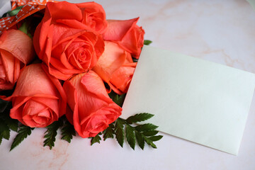 postcard mockup. beautiful bouquet of orange roses and an envelope. congratulation. invitation. flat lay