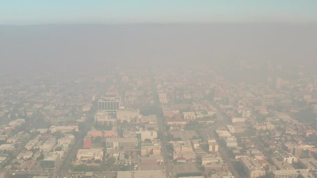 Hazy apocalyptic aerial of Downtown Los Angeles, skyscrapers in smog, low visibility