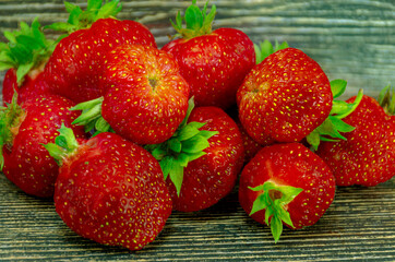 Tasty red berry strawberry on a wooden table.