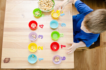 Little child doing simple math exercises. Early education, counting game. Preschool exercise for kids. Sequence from 1 to 10.