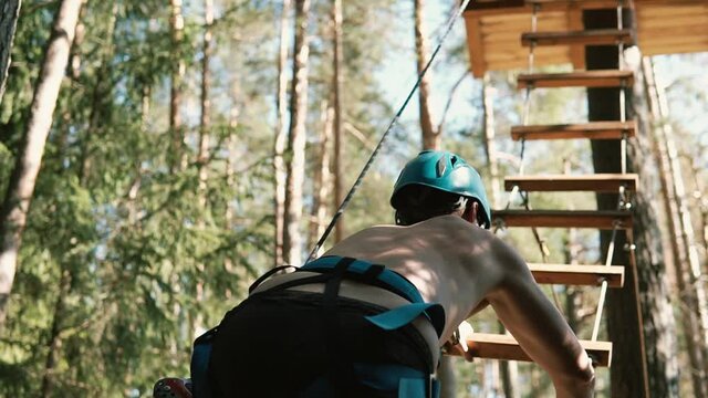 a man climbs the stairs to the platform for the descent of the troll in forest