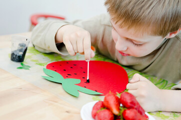Child draws a strawberry. Exercises for hand training. Early preschool education.