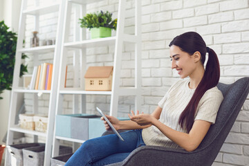 Young woman having video conference call via tablet computer in home office. Online work, communication and education