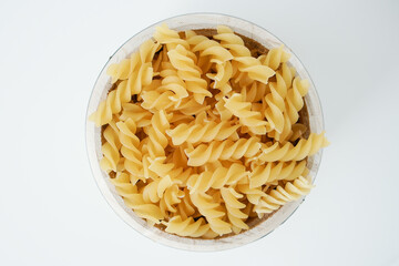 Raw dry uncooked Fusilli pasta spaghetti noodle on white background Good for basil tomato pesto sauce Homemade fresh Italian food organic whole wheat vegan spaghetti noodle for a healthy meal