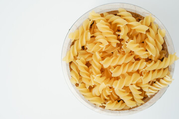 Raw dry uncooked Fusilli pasta spaghetti noodle on white background Good for basil tomato pesto sauce Homemade fresh Italian food organic whole wheat vegan spaghetti noodle for a healthy meal