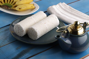 PUTTU or WHITE RICE PITTU ,Kerala special breakfast items made using rice flour which is very healthy and arranged in traditional way with  blue background