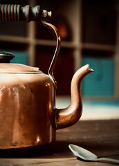 Old copper kettle on wood