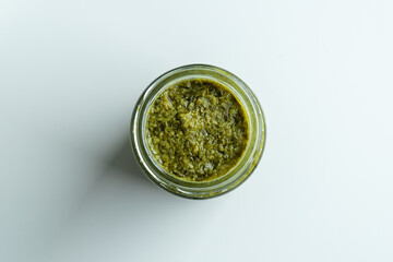 Background homemade cooking recipe green pesto pasta organic healthy food sauce in glass jar made from fresh basil leaf herb parmesan cheese nuts for healthy vegetarian vegan meal