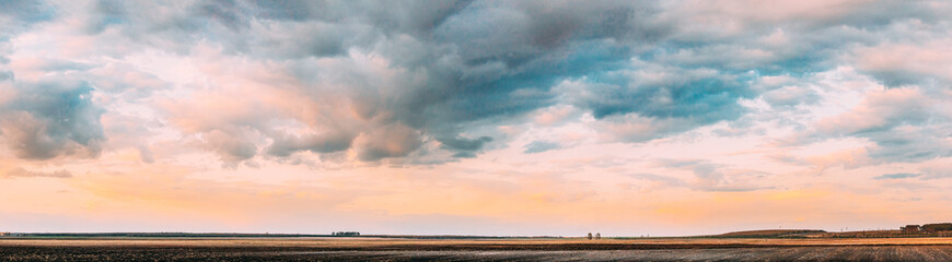 Sunset Sky Above Empty Spring Countryside Rural Soil Landscape. Field Under Sunny Spring Sky. Agricultural Landscape With Copy Space. Panorama