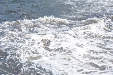 during the day the sea waves and splashes of small drops fall on the shore