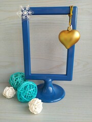 Blue rectsngual photo frame on a light blue wooden background with blue and white balls and multicolored glasses
