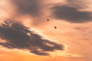 Two balloons on a background of pink sunset and clouds