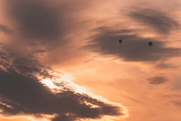 Two balloons on a background of pink sunset and clouds
