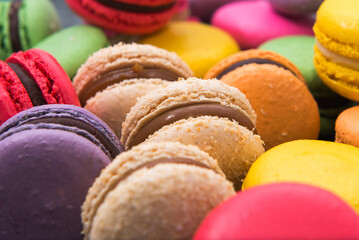 Postre de macarons de colores con rellenos varios sobre tabla azul en primer plano 