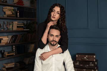 Cropped portrait of young couple hugs in old antique room. Tenderness and passion. Lovely romantic couple embracing, pretty charming mrs with jewelry, rich confident mr with stubble.