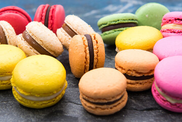 Postre de macarons de colores sobre tabla azul vistos desde arriba 