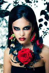 pretty brunette woman with rose jewelry, black and red, bright make up a vampire closeup red lips