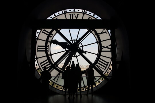 silueta de gente con el reloj del museo de orsay de fondo