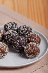 Energy balls on a plate on a wooden background