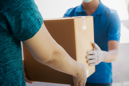 Young woman receiving parcel from delivery man. Delivery Service.