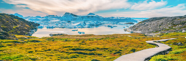Hiking trail path in Greenland arctic nature landscape with icebergs in Ilulissat icefjord....