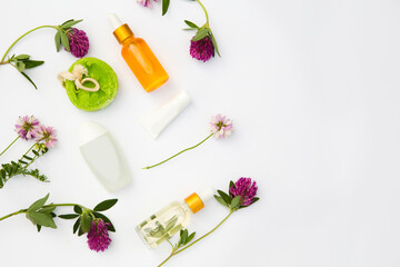 Obraz na płótnie Canvas Spa still life with Natural Serums in glass bottle, cream, soap and wildflowers on a white background. Flat lay. copy space. body care concept. 