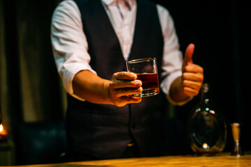 hand holding ice whisky glass, clinking glasses	