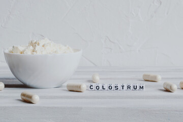 Pills capsules with colostrum, on a white background