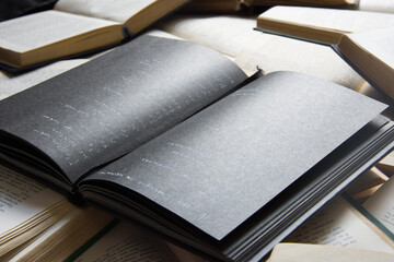 Notepad with black pages lies on a pile of books
