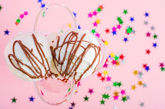 Ice cream balls with chocolate on a pink background with stars. Summer time. Celebration background