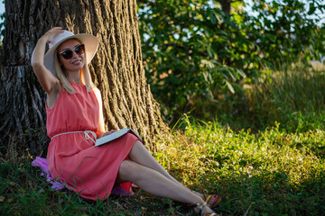 Woman reading a book under a tree