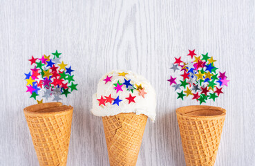 Ice cream cones decorated with stars on a white wood background. A wafer-style ice cream cone. Summer time.