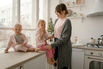A young mother spends time with her little daughters at home.