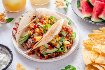 Taco tortillas filled with barbecue chicken and topped with pineapple salsa