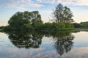 Summer landscape in Belarus. Colorful sky and reflections in the river at dawn.