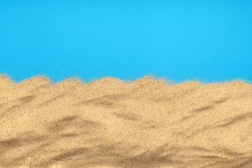 Plakat The sand isolated on blue background. Flat lay top view. Copy space.