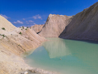 Fototapeta na wymiar Beautiful summer landscape. Turquoise water between sand mountains in the desert.