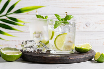 Mojito cocktail on wooden table. Summer refreshing drink on the wooden tray.