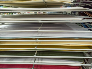 Sheets of colored cardboard for designer creative works.Stacks of colored drawing paper in the store.Colorful art papers on a shelf for sale in a stationery store.