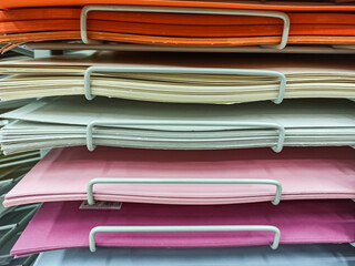 Sheets of colored cardboard for designer creative works.Stacks of colored drawing paper in the store.Colorful art papers on a shelf for sale in a stationery store.