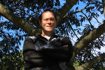 man leaning against tree
